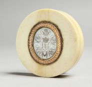 A GEORGIAN IVORY CIRCULAR BOX, the top with an oval crest. 2.25ins diameter.