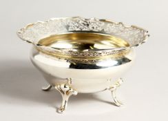 A CIRCULAR SILVER PIERCED BOWL on four curving legs 6ins diameter, maker James & William Dixon.