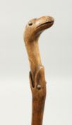 A RUSTIC WOODEN WALKING STICK, a snake eating a bird. 33ins long.