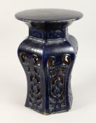 A CHINESE POTTERY SEAT with circular top and pierced sides. 1ft 8ins high.