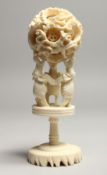 A FAUX IVORY PUZZLE BALL on a stand. 7ins high