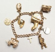 A 9CT GOLD CHARM BRACELET with 10 charms including Christian icons 37gmS.