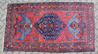 A GOOD SMALL PERSIAN RUG, deep red ground with a central large medallion, flanked by stylised vases.