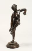 AFTER THE ANTIQUE. A GOOD BRONZE OF A NUDE holding her left leg, on a circular base. 10ins high.