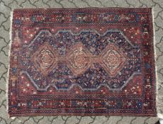 AN OLD PERSIAN RUG with three medallions (worn). 5ft 5ins long x 4ft 6 ins wide.