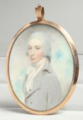 A GEORGIAN OVAL MINIATURE OF A YOUNG MAN, half length in a gilt frame. 2.75ins x 2ins.