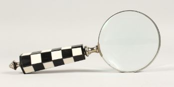 A MAGNIFYING GLASS with a chequered handle.