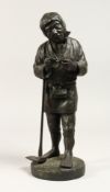 A JAPANESE BRONZE STANDING FIGURE OF A MAN holding a pipe and shovel. 12ins high.