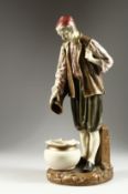 A ROYAL WORCESTER PORCELAIN FIGURE OF A TURK by Hadley, standing, pouring from a jug, into a bowl.