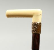 AN EDWARDIAN DANDY CANE with bone handle and gilt collar. 38ins long.