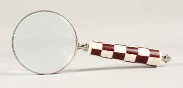 A MAGNIFYING GLASS with a chequered handle.