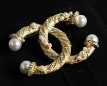 A CHANEL STYLE ENTWINED C BROOCH in a Chanel box.