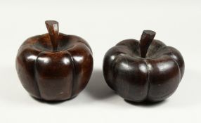 A LARGE PAIR OF CARVED WOOD PUMPKIN DOOR STOPS.