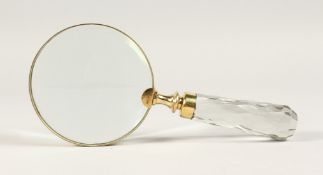 A MAGNIFYING GLASS with a cut glass handle.