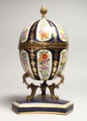 A LARGE SEVRE STYLE BLUE AND GILT EGG SHAPED CASKET AND COVER, painted with flowers on a