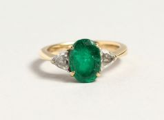 A SUPERB EMERALD AND DIAMOND THREE STONE RING in 18ct gold.
