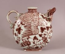 A CHINESE MING STYLE COPPER RED PHOENIX PORCELAIN POURING VESSE, with a moulded phoenix head handle,