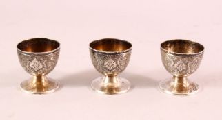 THREE PERSIAN WHITE METAL EGG CUPS, 4.5cm high.