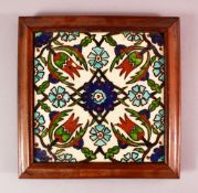 A FRAMED IZNIK STYLE POTTERY TILE SECTION, with a floral motif decoration, 26cm