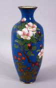 A JAPANESE MEIJI PERIOD CLOISONNE VASE, the blue ground with native display of flora, 24cm high