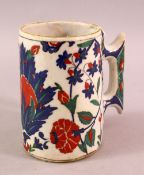 AN 18TH CENTURY TURKISH OTTOMAN IZNIK CUP / MUG, with a white ground and floral decoration, 13cm