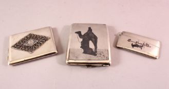 A GOOD IRAQI SILVER AND NIELLO CIGARETTE CASE, decorated with figures and a camel, the reverse