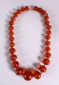 A 19TH CENTURY CHINESE CARVED AMBER BEAD NECKLACE, comprising 29 graduated size carved amber