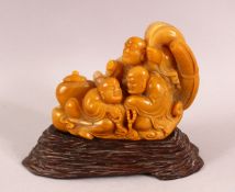 A CHINESE CARVED SOAPSTONE FIGURE OF LUOHAN, With a carved wooden stand, 13cm high