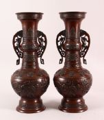 A PAIR OF JAPANESE RELIEF BRONZE VASES, with twin handles, relief birds and flora decoration, 40cm