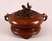 A CHINESE BRONZE TWIN HANDLED CENSER, the top with a pierced bat cover and dog final, with twin