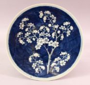 A 19TH CENTURY CHINESE BLUE & WHITE PRUNUS PORCELAIN DISH, the centre with a blue ground and
