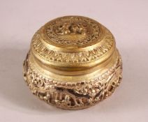 A BURMESE SILVER EMBOSSED BOX & COVER with moulded figural decoration, 11cm