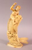 A JAPANESE MEIJI PERIOD CARVED IVORY FISH OKIMONO, the fish emerging from the water with a boy on