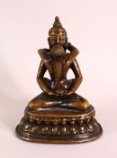 A TIBETAN GILT BRONZE FIGURE OF SEATED buddha and figure, in a semi erotic pose with a vessel,