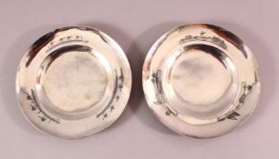 TWO IRAQI SILVER AND NIELLO DECORATED CIRCULAR DISHES, the borders engraved with river lanscapes and