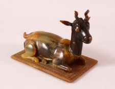 A 19TH CENTURY INDIAN CARVED HORN MODEL OF A RECUMBENT DEER, 12cm long.