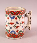A TURKISH POTTERY IZNIK CUP / MUG - with red green and blue decoration, 13cm high