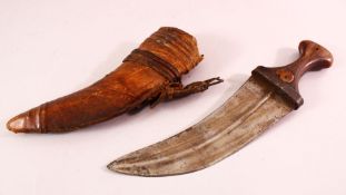 AN ARAB JAMBIYA DAGGER, with horn handle and hide scabbard, 31cm long.