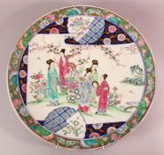 A LARGE JAPANESE POLYCHROME PORCELAIN CHARGER, depicting females in a garden setting, the