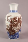 A LARGE CHINESE UNDERGLAZE BLUE & COPPER RED PORCELAIN VASE, decorated with dragons amongst waves,