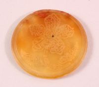 AN ISLAMIC CIRCULAR YELLOW AGATE PLAQUE, with engraved decoration, 6cm diameter.