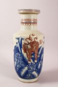 A CHINESE UNDERGLAZE BLUE & COPPER RED PORCELAIN VASE, decorated with lion dogs and waves, six
