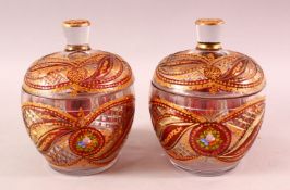 A PAIR OF BOHEMIAN RED ENAMELLED GLASS JARS, each with enamel and gilt work, 20cm each