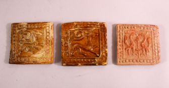 THREE 16TH CENTURY POTTERY TILE SECTIONS, each with moulded decoration of animals, 11cm approx. (3)