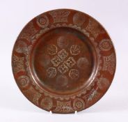 A 19TH CENTURY ISLAMIC CALLIGRAPHIC COPPER DISH, with floral motif and panels of calligraphy, 24cm