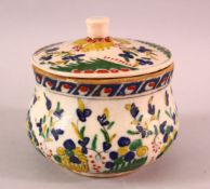 A TURKISH OTTOMAN KUTAHYA POTTERY JAR & COVER, decorated with flora 11cm high.