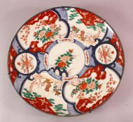 A LARGE JAPANESE MEIJI PERIOD PORCELAIN IMARI CHARGER, depicting shi shi dogs with floral