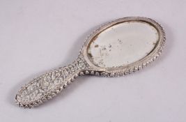 A 19TH CENTURY INDIAN SILVER HAND MIRROR, with embossed decoration of flora, 24cm.