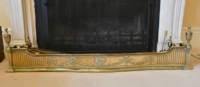 AN ADAM DESIGN BRASS FENDER and five irons. 4ft 8ins long.