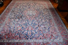 A VERY GOOD LARGE PERSIAN FLORAL CARPET, mainly in red and blue. 11ft 6ins x 8ft 6ins.